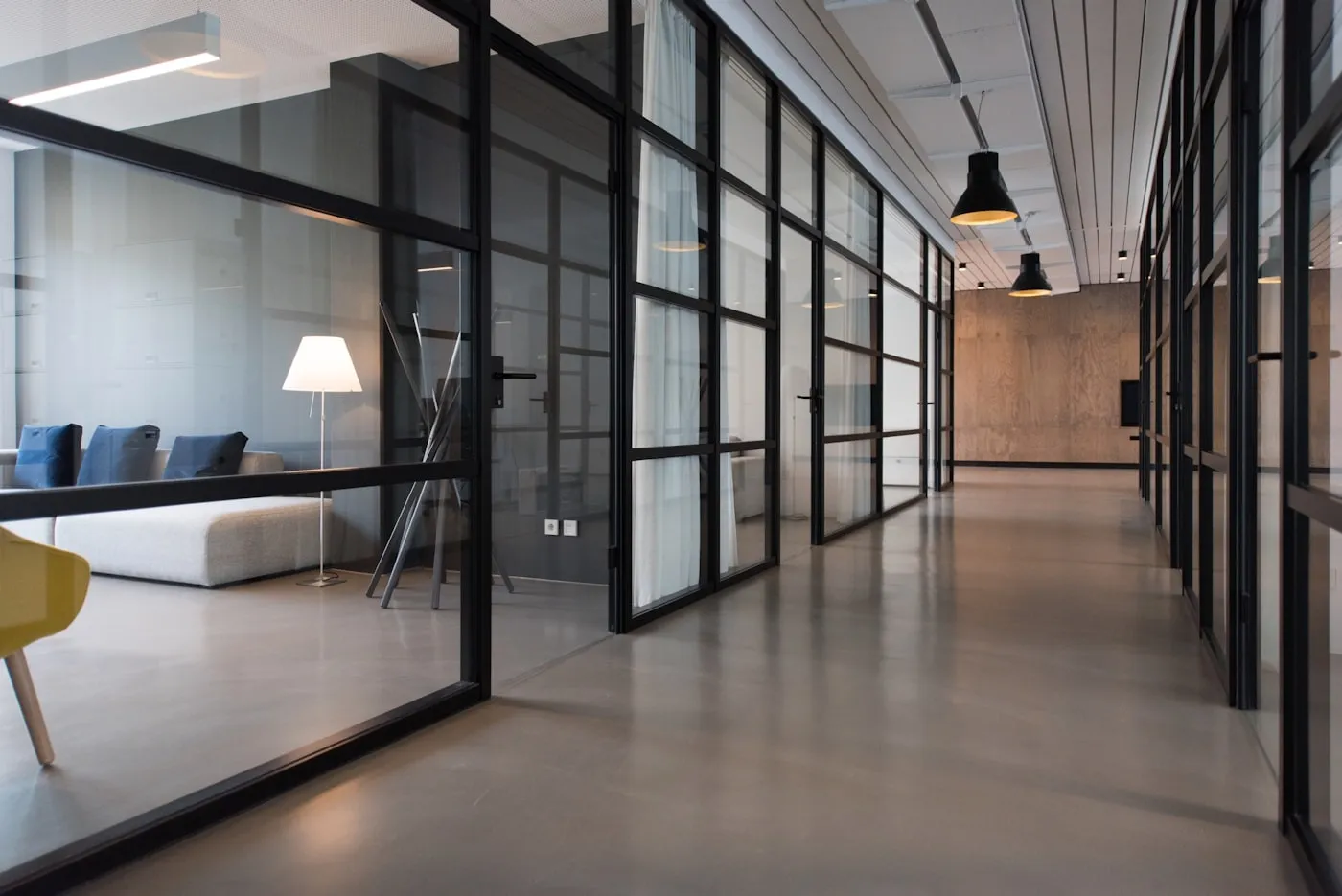 A modern office corridor with glass partitions in a corporate workspace